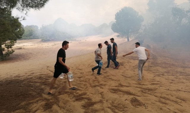 Vatandaşlar ellerinde dallar ve yerden topladıkları kumlarla yangına müdahale etti